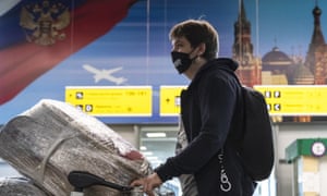 A man wearing a face mask to protect against coronavirus waits in line to check-in at Sheremetyevo international airport, outside Moscow, Russia, Saturday, Aug. 1, 2020