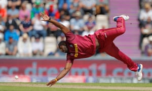 West Indies’ Andre Russell attempts to field a ball off his own bowling.