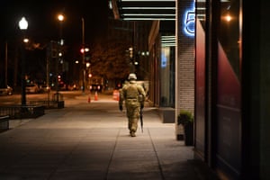 A lone National Guardsman walks down the sidewalk the night before the inauguration