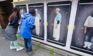 Visitors look at photographs by the French artist K-Narf in Kyoto, Japan