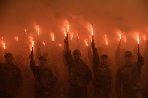 Members of Ukrainian special forces hold aloft flares at a ceremony