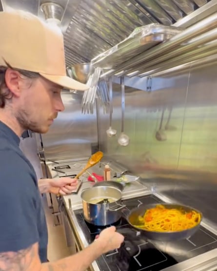 Brooklyn Beckham at a stove cooking pasta in a pan.