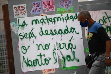 A man walks past a poster reading ‘Motherhood will be desired or it will not be. Legal abortion’ in Caracas, in January.