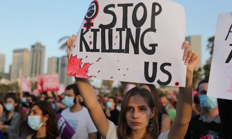 A woman holds a sign at a protest march against violence toward women in Tel Aviv in June 2020.