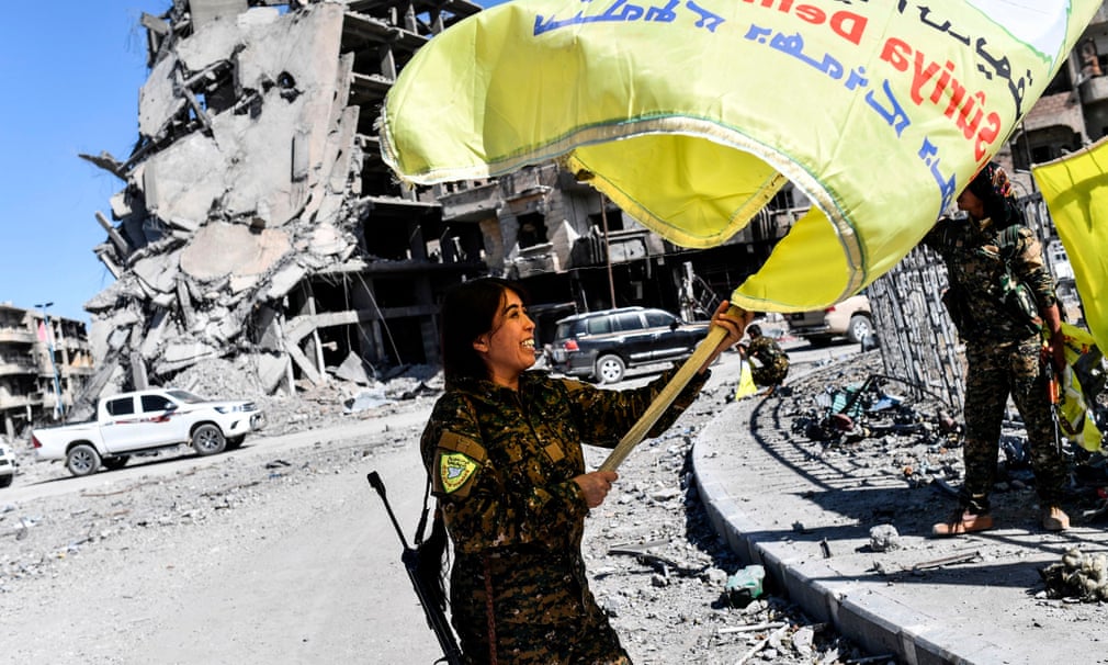 Rojda Felat, comandante delle Forze Democratiche Siriane (SDF), sventola la bandiera dell'YPG a piazza Al-Naim, Raqqa, dopo averla conquistata. Credits to: Bülent Kılıç/AFP/Getty Images.