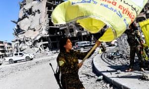 Rojda Felat, a Syrian Democratic Forces (SDF) commander, waves her group’s flag at the iconic Al-Naim square