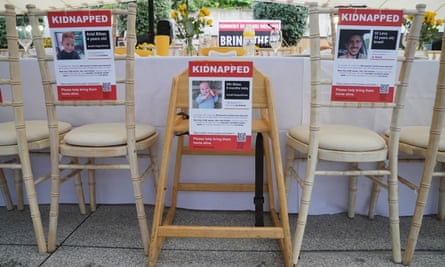 Empty chairs decorated with signs of missing people 