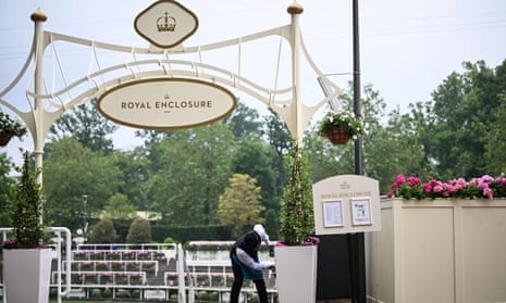 A member of the Ascot staff cleans a flower pot outside the Royal Enclosure.