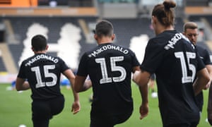 Hull players warm up in MacDonald shirts last September.