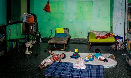 Two babies lies on mattresses on the floor of the former reception area