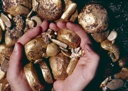 Hands in a pile of gold bars