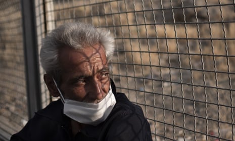 A homeless man wearing a face mask sits in an outdoor shelter in Tehran amid the coronavirus outbreak