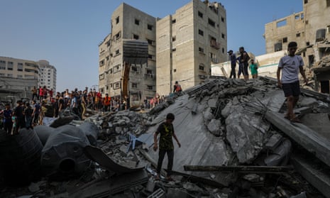 Palestinians search among the rubble of the destroyed Al Faseih family house following an airstrike in the Al Shatea refugee camp, Gaza on Tuesday.