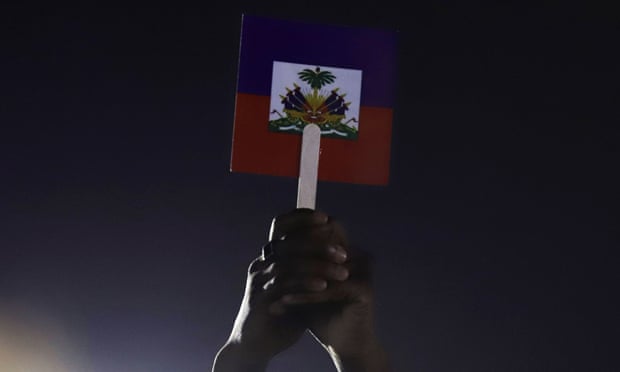 Seseorang memegang bendera Haiti