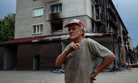 A local resident stands in front of a burnt residential building due to constant shelling in Siversk, Donetsk region on 20 August.