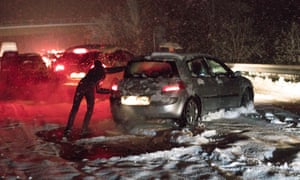 A car is pushed through the snow in La Rioja, northern Spain