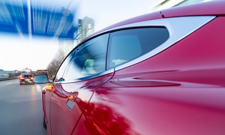 Electric powered US car drives while dawn on German Autobahn A9 into the city of Munich.<br>- long exposure photograph - camera mounted to the side of the car - car made in the USA -