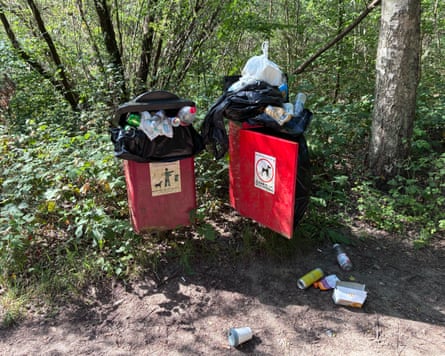 Overflowing dog waste bins in a wood.