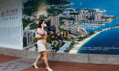 A woman walks past an advertisement for a property development by Evergrande in Emerald Bay in Hong Kong.