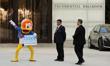 A demonstrator wearing a Donald Duck costume dances in front of the Trump International Hotel.