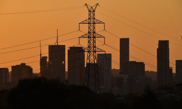 High tension electricity cables and city skyline at sunset