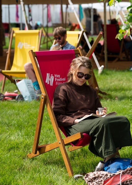 People relax on deckchairs on the lawn.