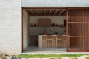 An indoor-outdoor kitchen with a large wooden screen at the Curl Curl House. Architects were inspired by the walled homes of Mexico.