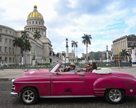 Tourists ride in an old American car used as a taxi in Havana in February 2026.