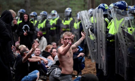 A reveller puts his hands up in front of riot police at the scene of a rave in Thetford forest, Norfolk.