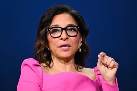 woman in pink dress and glasses speaks