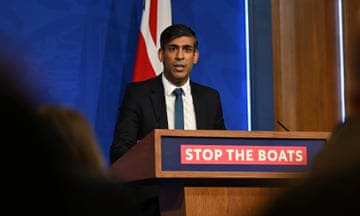 Rishi Sunak speaks from a lectern that features a sign that reads: 'stop the boats'