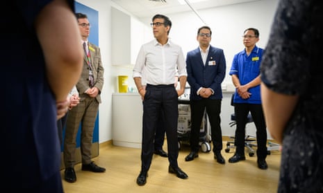 Rishi Sunak speaks with medical staff during a visit to Woking community hospital.