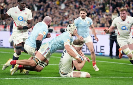 Alex Coles goes to touch the ball down despite the attentions of a tackler in England’s Six Nations game against France on 14 March 2026