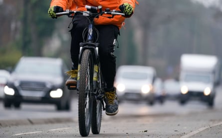 Quelqu'un roule le long d'une piste cyclable à côté d'une circulation dense à Birmingham.