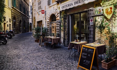small neighbourhood restaurant in Trastevere district of Rome on cobblestone street with tables outside and blackboards listing the menu
