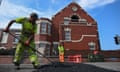 Workers repair the road and garden walls around the Southport Islamic Society mosque, which was attacked by far-right extremists last month.