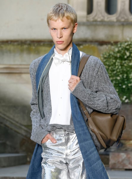 A model in a mash-up of a cardigan, bow tie and metallic trousers.