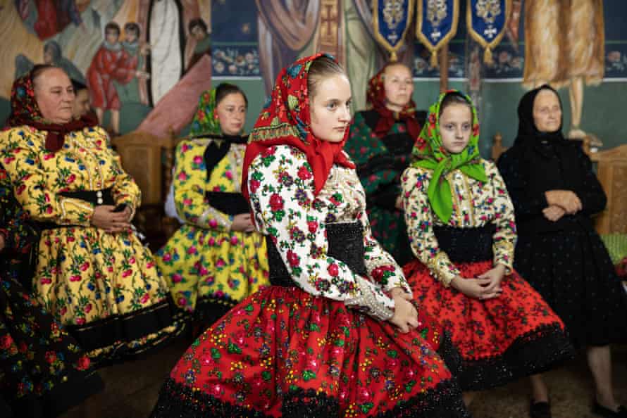 Women in traditional costumes watch a wedding ceremony in a Romanian Orthodox church in the village of Tur.