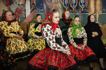 Women dressed in traditional costumes watch a wedding ceremony in a Romanian Orthodox church in the village of Tur.
