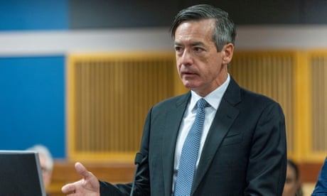 man wearing black suit and blue tie looks forward man wearing black suit and blue tie looks forward