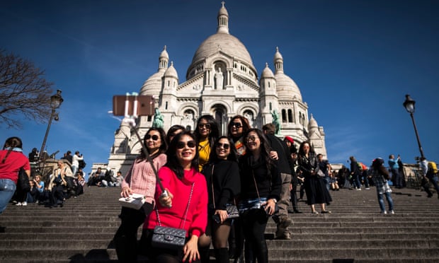 Tourists take selfies in front of the Sacre Coeur basilica, Paris.