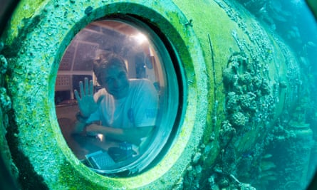 Fabien Cousteau waves from inside Aquarius Reef Base, a laboratory 63 feet below the surface in the waters off Key Largo, Florida in 2014