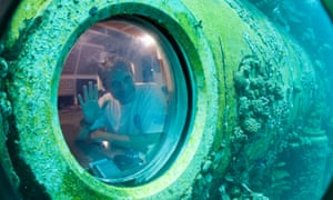 Fabien Cousteau waves from inside Aquarius Reef Base, a laboratory 63 feet below the surface in the waters off Key Largo, Florida in 2014