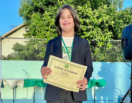 A fifth-grade boy with his school diploma.
