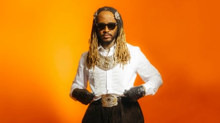 Thundercat wearing a white shirt, dark trousers and gloves