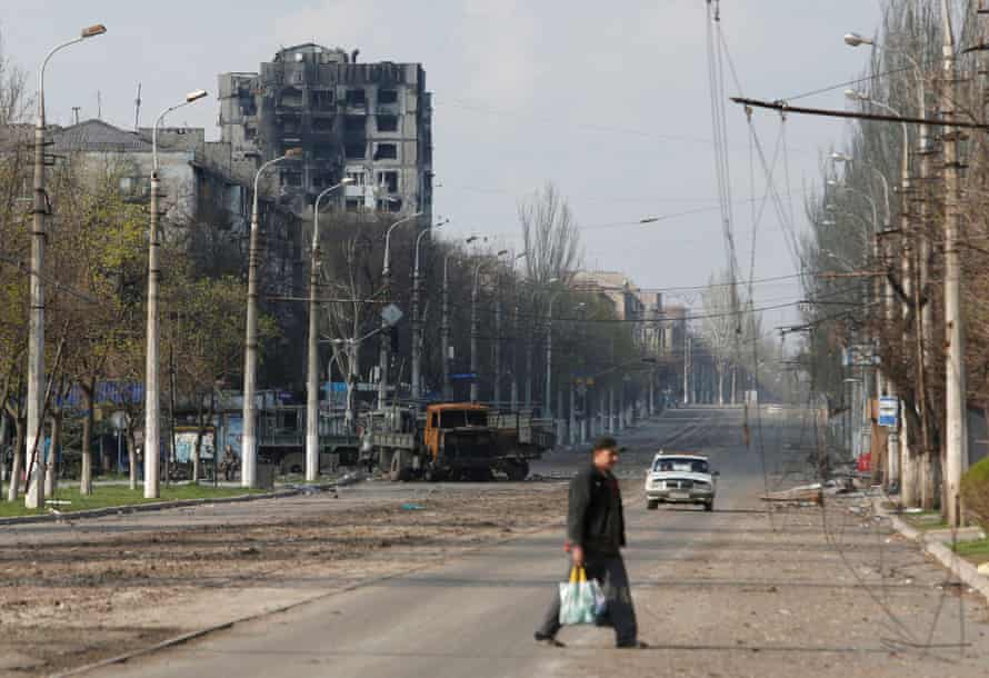 A local resident crosses a damaged street in Mariupol, Ukraine.