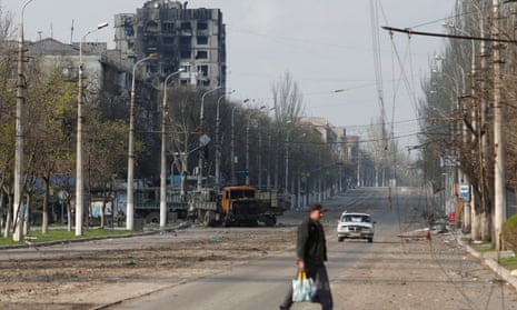 A local resident crosses a damaged street in Mariupol.