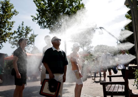 Spectators cool down at a water spray station