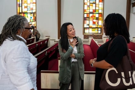 a woman speaking to two other women in a church
