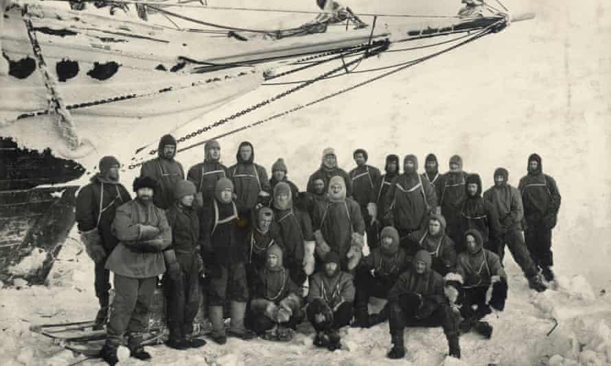 Officers and crew pose under the bow of the Endurance at Weddell Sea Base.